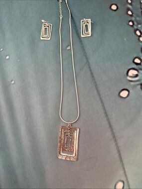 Silver necklace and matching earrings.